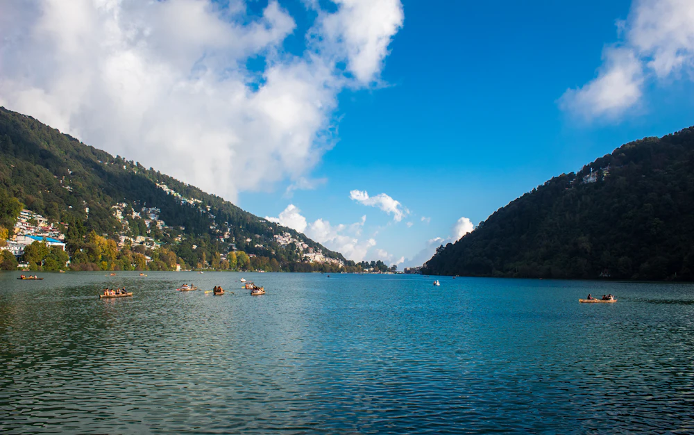 Naini Lake with boats and forested hills in Nainital