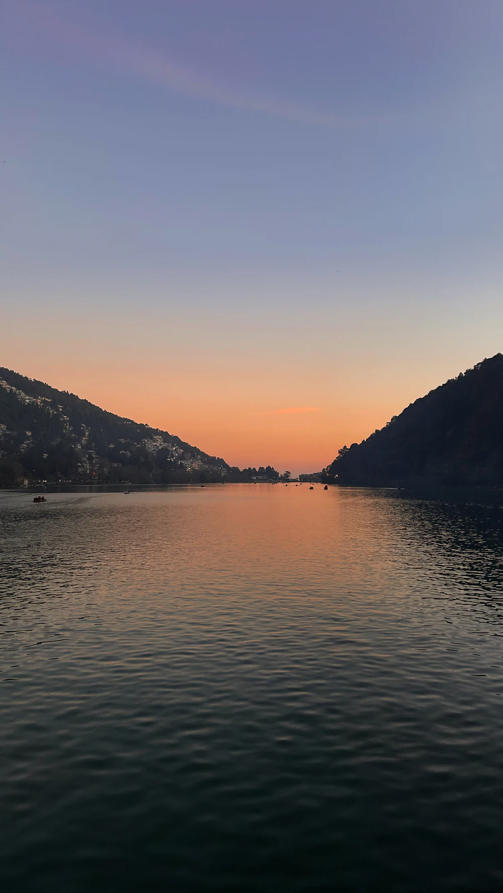Naini Lake at sunset with mountains behind