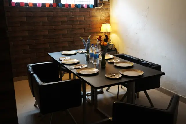 Dining table with wooden plates and flowers at the hotel